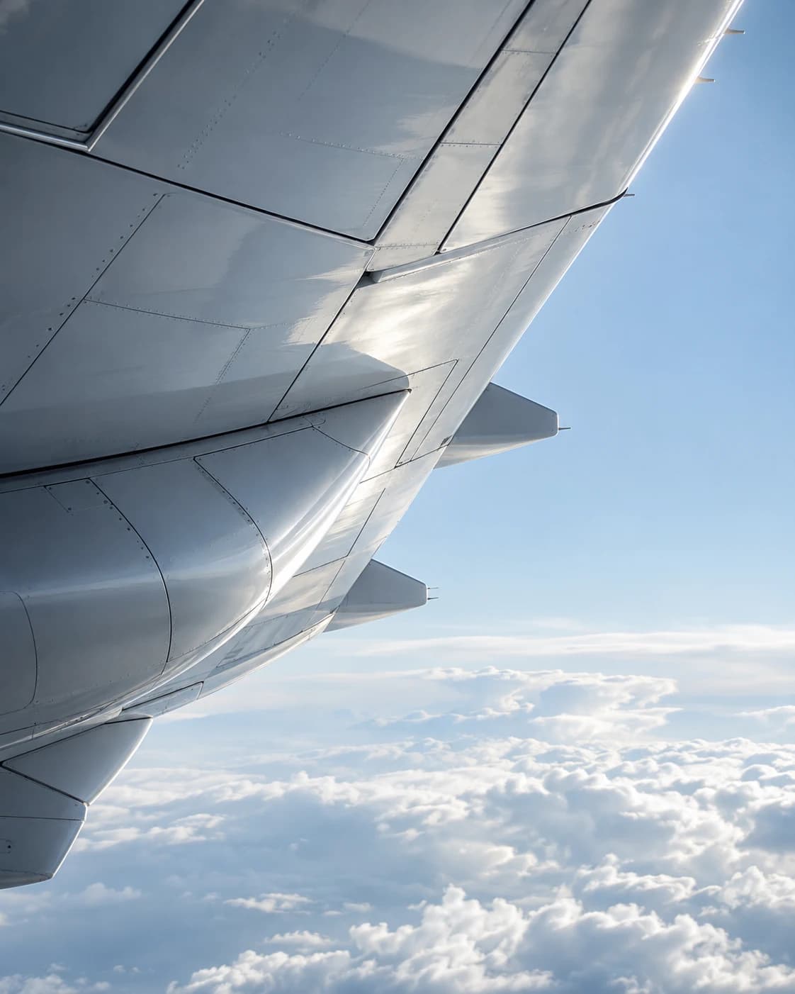 A sunlit aircraft wing above the clouds